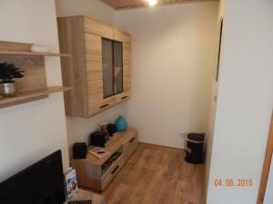 a living room with a television and wooden cabinets at Schlupfwinkel Mohnen Mit E-Ladestation in Clausthal-Zellerfeld +10 photos