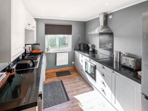 a kitchen with white cabinets and black counter tops at March Brown in Garmouth