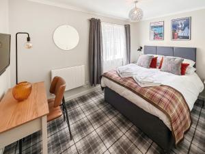 a bedroom with a bed and a desk in it at March Brown in Garmouth