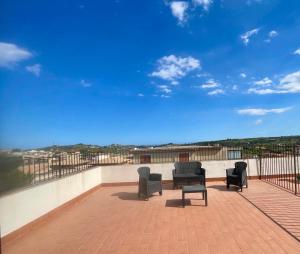 a balcony with two chairs and a table and chairs at Simonetta's Rooms in Noto