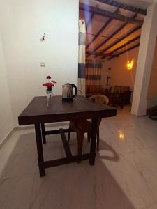 a wooden table with a vase of flowers on it at 39 House Weligama in Weligama