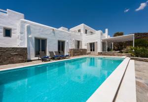 a villa with a swimming pool in front of a house at Luxury Complex Ninemia Villas in Faros