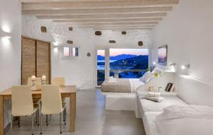 a white bedroom with a bed and a dining table at Crystal Suites in Mikonos
