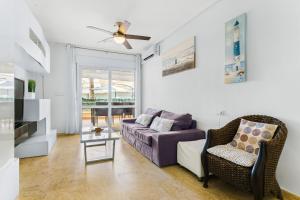 a living room with a purple couch and a chair at Aguamarina 2 Sunrise in Orihuela +10 photos