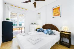 a bedroom with a white bed with blue pillows at Aguamarina 2 Sunrise in Orihuela