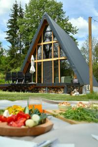 a table with a plate of food in front of a cabin at Cabana Zeneris in Vulcana de Sus