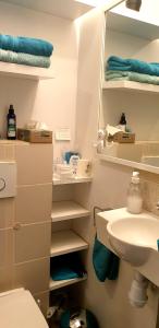 a bathroom with a sink and a toilet and towels at Petite chambre confortable vignoble bourguignon in Brochon