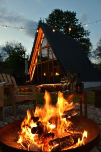 a fire pit with flames in front of a house at Cabana Zeneris in Vulcana de Sus