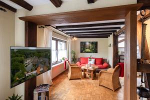 a living room with a tv and a red couch at Ferienhaus Rosa in Mechernich