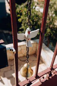 a white bird on a chain with a bell at Casa Om Shanti in Passa Quatro