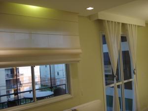 a room with a window with curtains and a balcony at Apartamento Aeroporto in Porto Alegre