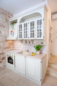 a kitchen with white cabinets and a sink at Antica casa Scesciola in Rutigliano +9 photos