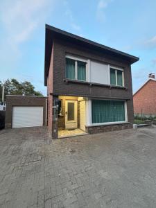 a house with a brick driveway in front of it at The Wandering House in Tremelo