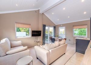a living room with a couch and a tv at Snainton Luxury Lodges in Ebberston +35 photos