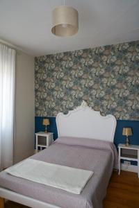 a bedroom with a bed with a floral wallpaper at Maison Hormidas in Crouseilles