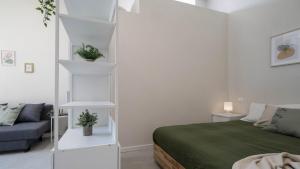 a white bedroom with a bed and a couch at Casa del Falegname - Loft Rovere con cucina in San Giovanni in Bosco