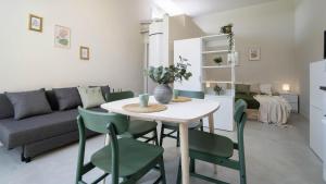 a living room with a table and green chairs at Casa del Falegname - Loft Rovere con cucina in San Giovanni in Bosco