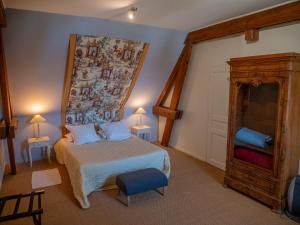 a bedroom with a bed with a large painting on the wall at La Ferme de la Sensée in Gouy-sous-Bellonne
