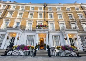 a large white building with flowers in front of it at City Prime Kensington in London