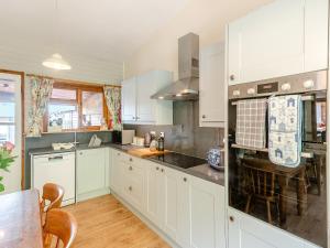 a kitchen with white cabinets and a counter top at Captains Quarters - 16266 in Staithes +28 photos