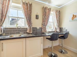 a kitchen with a sink and two chairs at Squirrel Cottage - Uk37886 in Stanhope +11 photos