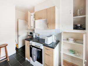 a kitchen with white cabinets and a stove at Sunset In Southampton in Southampton