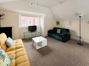 a living room with a couch and a tv at Sunset In Southampton in Southampton