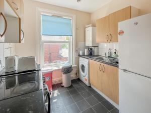 a kitchen with a refrigerator and a washer and dryer at Sunset In Southampton in Southampton