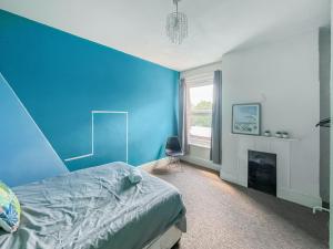 a blue bedroom with a bed and a fireplace at Sunset In Southampton in Southampton +12 photos