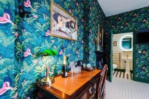a room with colorful wallpaper and a desk with a lamp at Godstall Lane Boutique Accommodation in Chester