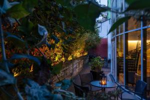 a patio with tables and chairs and a building at Hotel The Augustin in Brussels