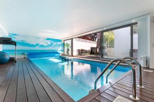 a swimming pool in a house with a wall of windows at Luxury by ON Apartments in Porto