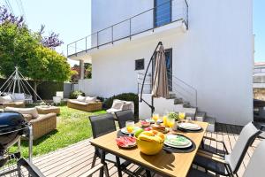 a patio with a wooden table with food on it at Luxury by ON Apartments in Porto