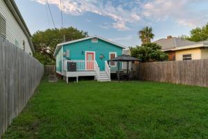 a blue house in a yard with a fence at Sandy Turtle-Gone to the Beach Be Back Never in Galveston
