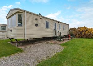 a tiny house on a trailer in a yard at Rowanbank Caravan Park in Beckfoot