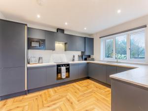 a kitchen with gray cabinets and a wooden floor at The Bunker - Uk47763 in Bamburgh +26 photos