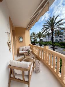 a balcony with a table and chairs and palm trees at Moraira Castle Boutique Apartment in Moraira