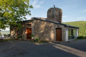 a stone house with a chimney on the side of it at Burg Coraidelstein in Klotten