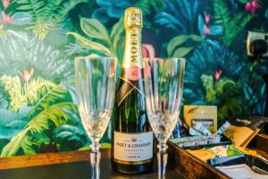 a bottle of wine sitting next to two champagne glasses at Godstall Lane Boutique Accommodation in Chester