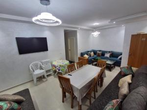 a living room with a table and a couch at Appartement Residence Tafoult IMIOUADDAR in Agadir nʼ Aït Sa