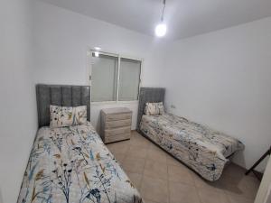 a bedroom with two beds and a window at Appartement Residence Tafoult IMIOUADDAR in Agadir nʼ Aït Sa +21 photos