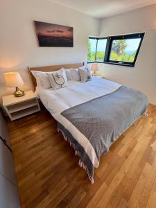 a bedroom with a large bed and two windows at The Seahorse Torbay in Torquay