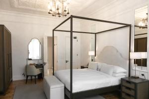a bedroom with a canopy bed and a desk at âmé by NOAH in Cape Town