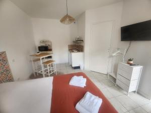 a room with a bed and a desk with a television at Le Petit Lamballais in Lamballe Armor