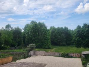 a garden with a stone wall and trees in the background at Le Petit Lamballais in Lamballe Armor