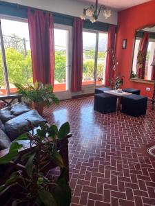 a living room with a couch and tables and windows at Hotel Praise in Capilla del Monte