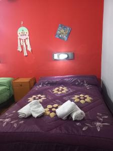 a bedroom with a purple bed with two towels on it at Hotel Praise in Capilla del Monte