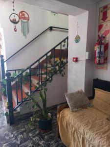 a living room with a couch and a staircase at Hotel Praise in Capilla del Monte +4 photos