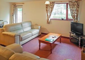 a living room with a couch and a coffee table at Avalon Cottages in Llangynin