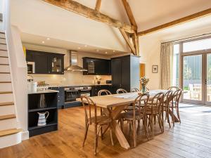 a kitchen and dining room with a wooden table and chairs at Hatchers Barn - Uk42080 in East Garston
